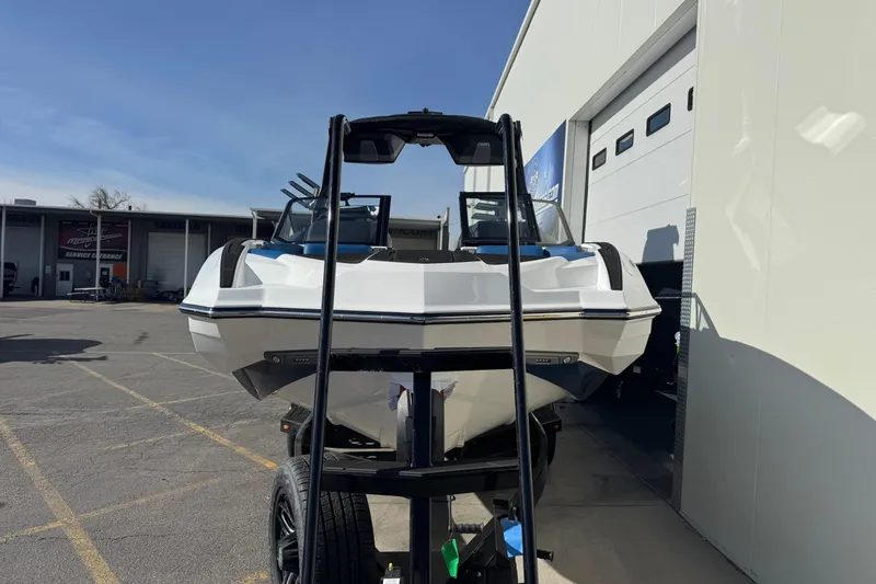The Image of 2026 Supra SE 575 boat on trailer outside dealership, sunny day. - 1
