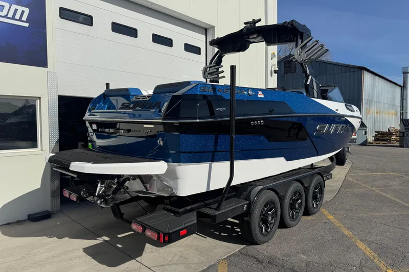 Slide: The Image of 2026 Supra SE 575 boat on trailer, parked outside a building. - 10