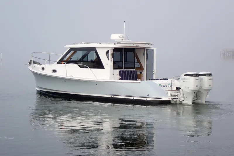The Image of 2023 True North 34 Outboard Express boat on calm water, featuring dual Suzuki engines. - 0