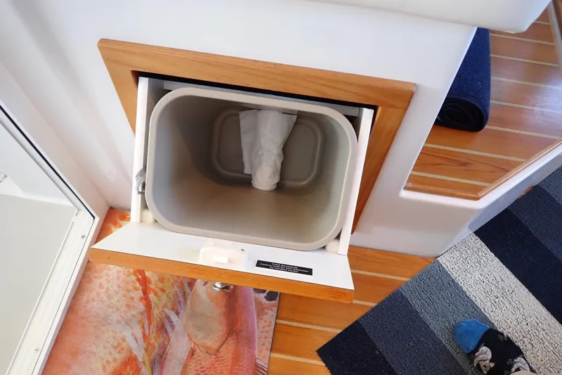 Slide: The Image of Built-in trash bin on 2023 True North 34 Outboard Express boat interior. - 104