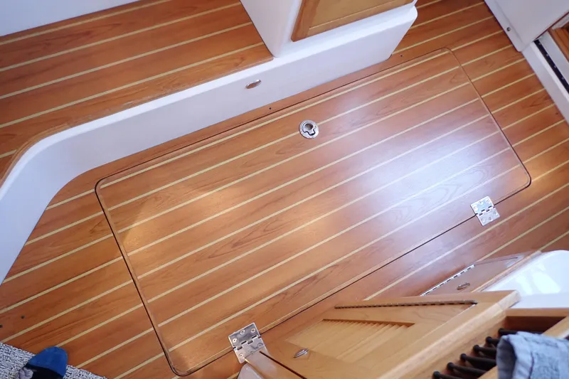Slide: The Image of Teak flooring on 2023 True North 34 Outboard Express boat interior. - 105