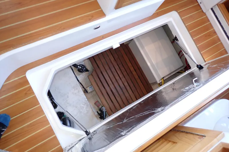 Slide: The Image of 2023 True North 34 Outboard Express boat interior with open hatch and wooden flooring. - 106