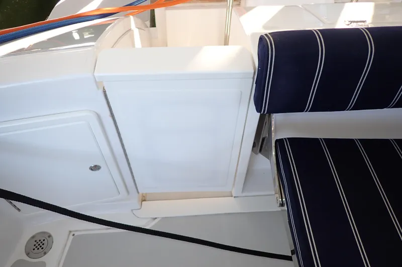 Slide: The Image of 2023 True North 34 Outboard Express interior with striped seating and storage compartment. - 120