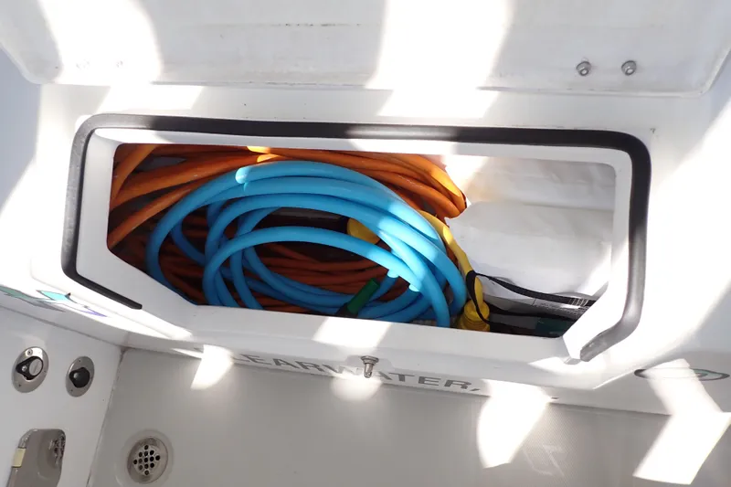 Slide: The Image of Storage compartment with colorful hoses on a 2023 True North 34 Outboard Express boat. - 123