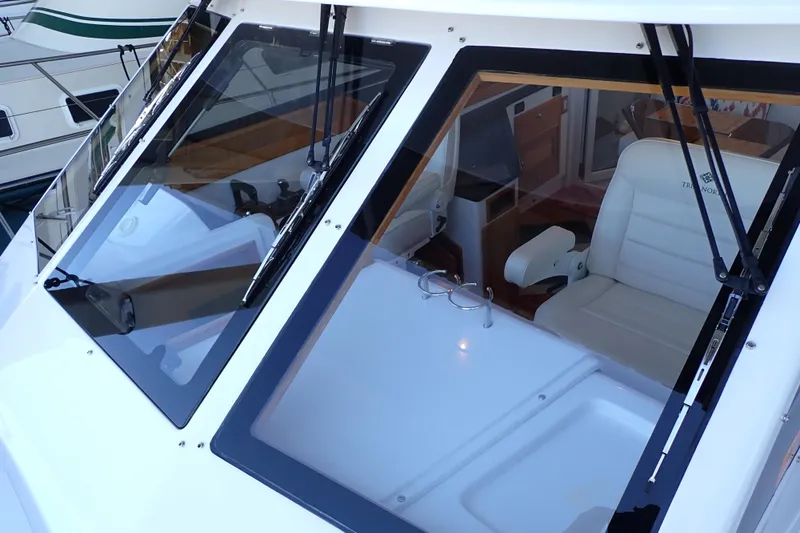 Slide: The Image of 2023 True North 34 Outboard Express boat interior with white seating and windshield wipers. - 144