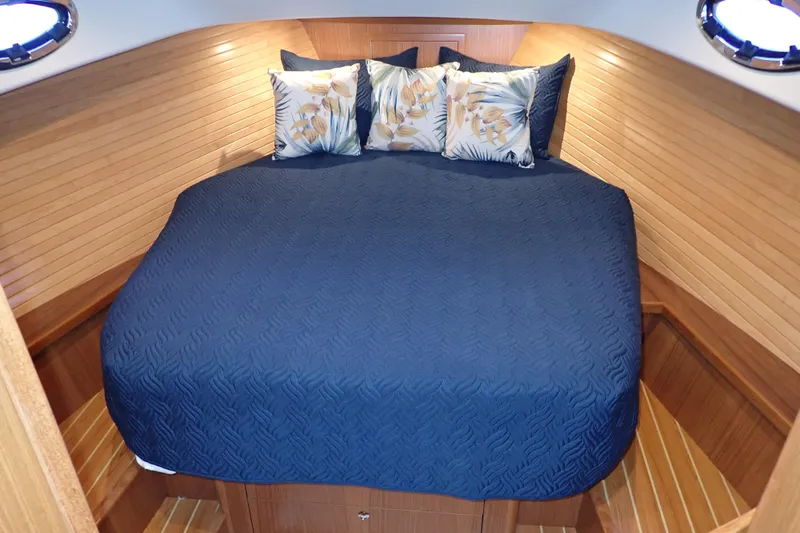Slide: The Image of Luxurious cabin interior of 2023 True North 34 Outboard Express with blue bedding. - 20