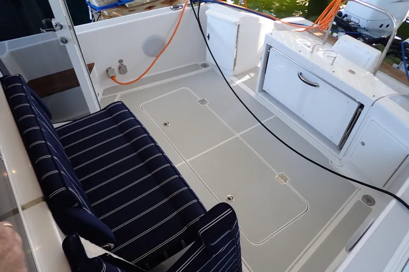 Slide: The Image of 2023 True North 34 Outboard Express boat interior with striped seating and storage compartments. - 32