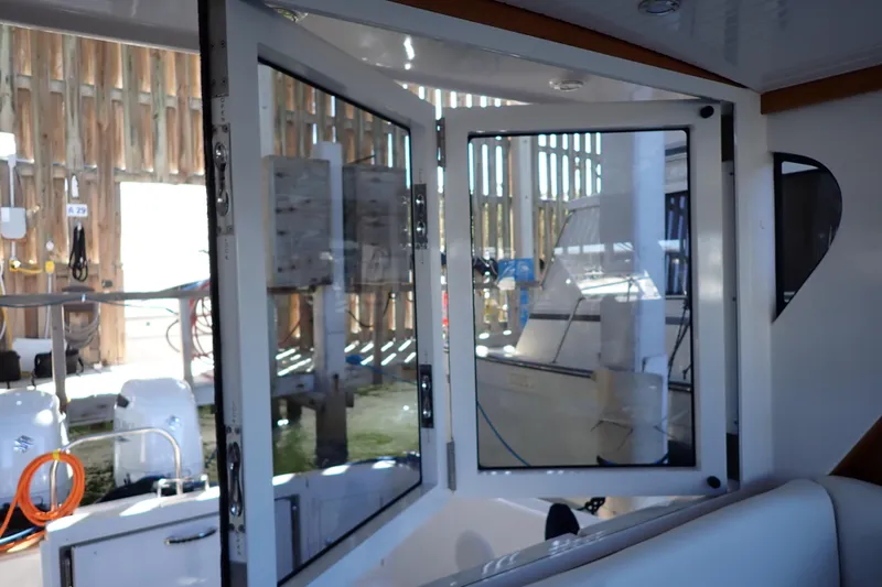 Slide: The Image of 2023 True North 34 Outboard Express boat interior with open glass doors. - 34