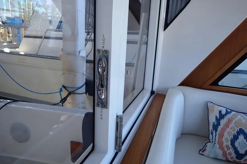 Slide: The Image of 2023 True North 34 Outboard Express interior with lockable door and cushioned seating. - 35