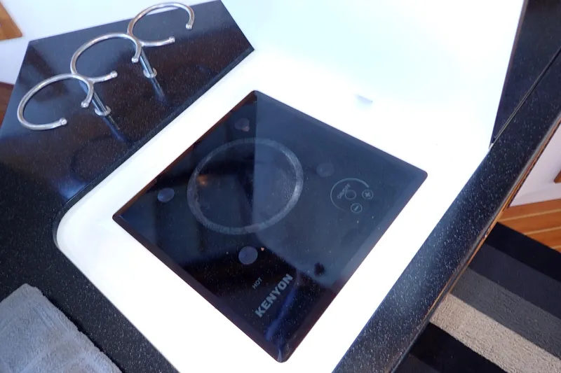 Slide: The Image of Modern Kenyon cooktop on 2023 True North 34 Outboard Express yacht kitchen counter. - 44