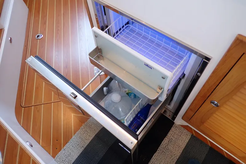 Slide: The Image of Open refrigerator on 2023 True North 34 Outboard Express boat, showing interior storage. - 47