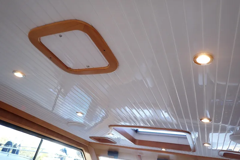 Slide: The Image of Ceiling of 2023 True North 34 Outboard Express with recessed lighting and wooden accents. - 62