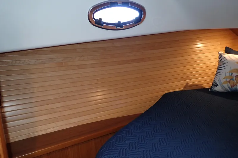 Slide: The Image of 2023 True North 34 Outboard Express cabin with wood paneling and cozy bedding. - 65