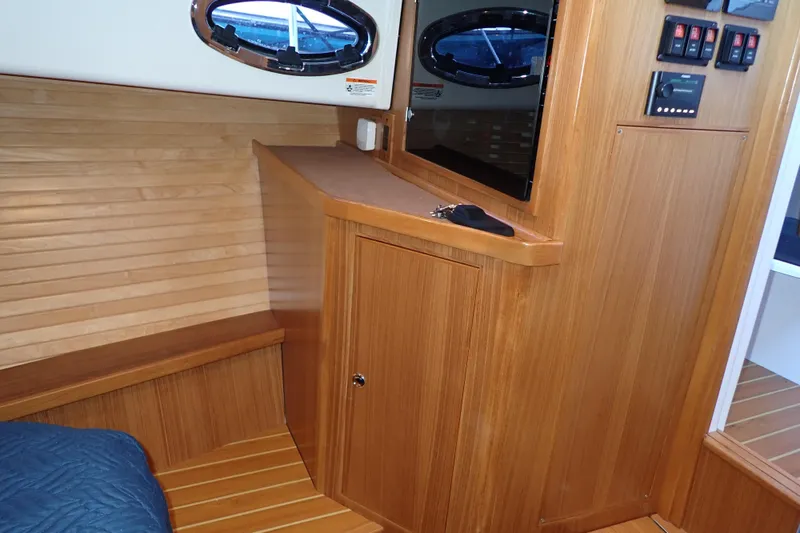Slide: The Image of Interior of 2023 True North 34 Outboard Express, featuring wood paneling and modern controls. - 67
