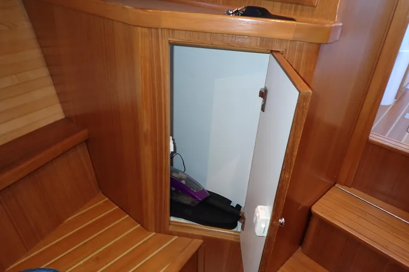 Slide: The Image of 2023 True North 34 Outboard Express interior with open wooden storage compartment. - 68