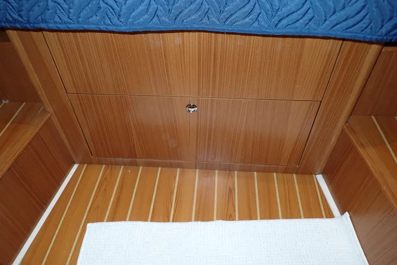 Slide: The Image of 2023 True North 34 Outboard Express cabin interior with wooden flooring and storage. - 71