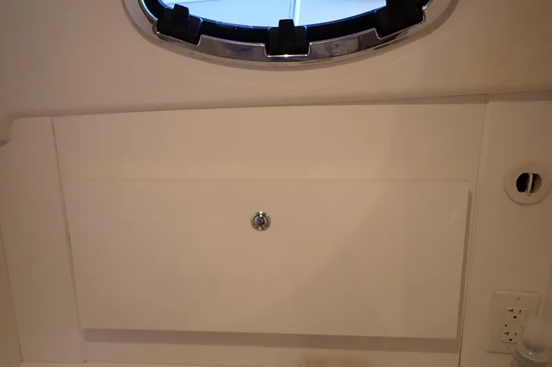 Slide: The Image of Cabin interior of 2023 True North 34 Outboard Express with porthole and storage compartment. - 77