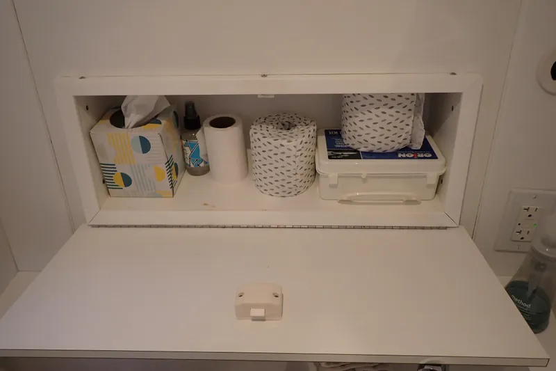 Slide: The Image of Storage compartment in 2023 True North 34 Outboard Express, holding tissues and cleaning supplies. - 78