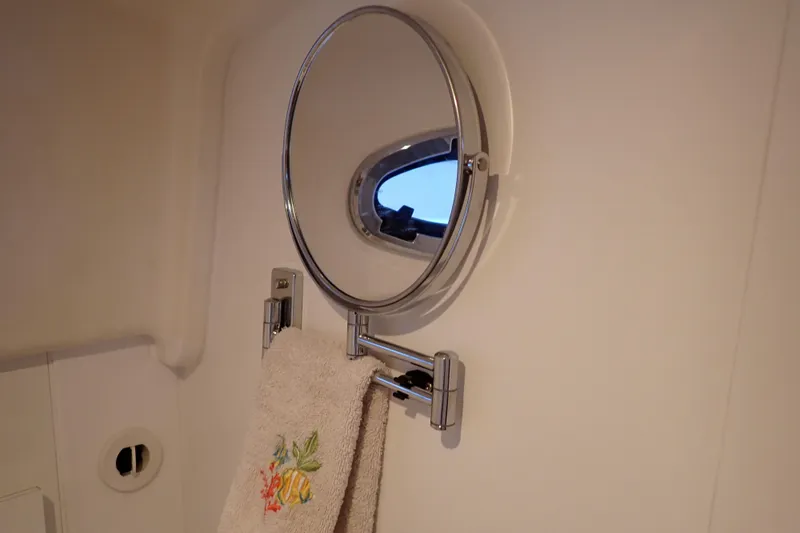 Slide: The Image of 2023 True North 34 Outboard Express bathroom with round mirror and towel holder. - 79