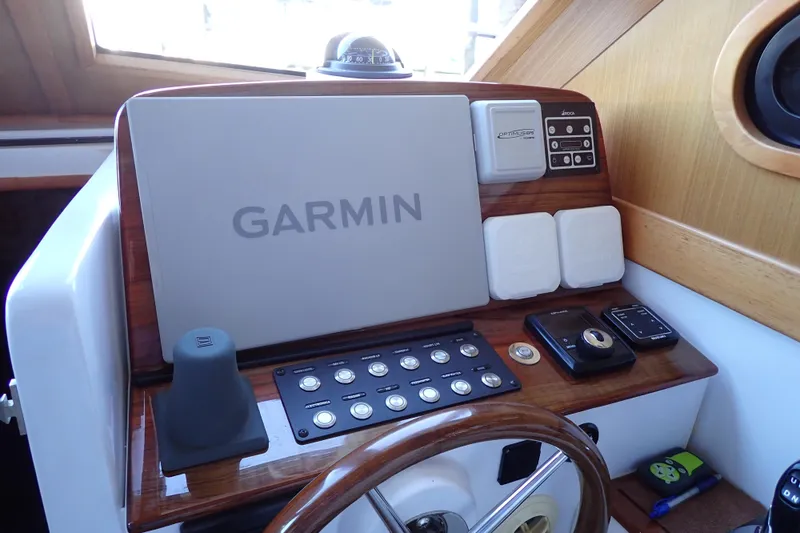 Slide: The Image of 2023 True North 34 Outboard Express helm with Garmin navigation system and control panel. - 8
