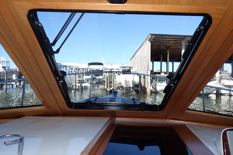 Slide: The Image of 2023 True North 34 Outboard Express boat interior view through windshield at marina. - 84