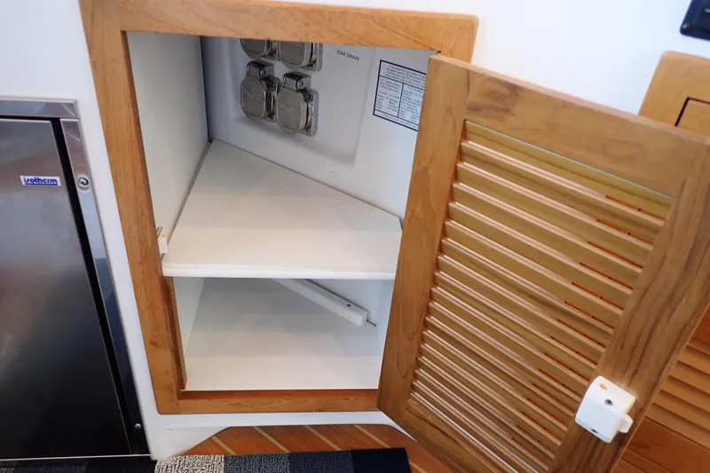Slide: The Image of Open wooden cabinet on 2023 True North 34 Outboard Express boat interior. - 94