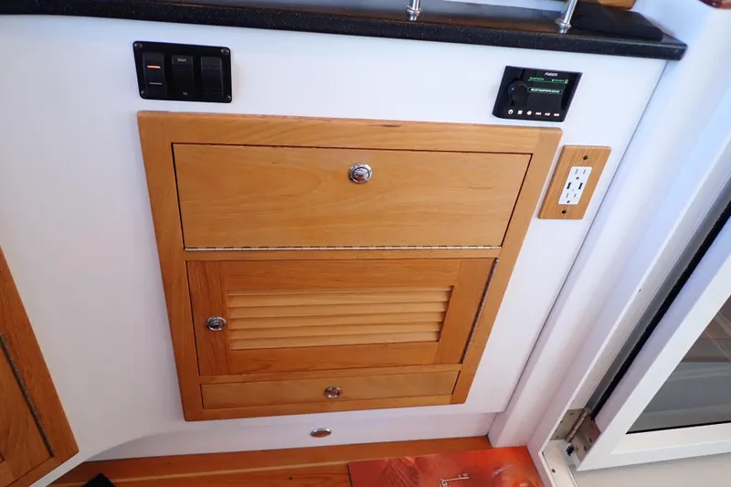 Slide: The Image of 2023 True North 34 Outboard Express interior with wooden cabinetry and electrical outlets. - 96