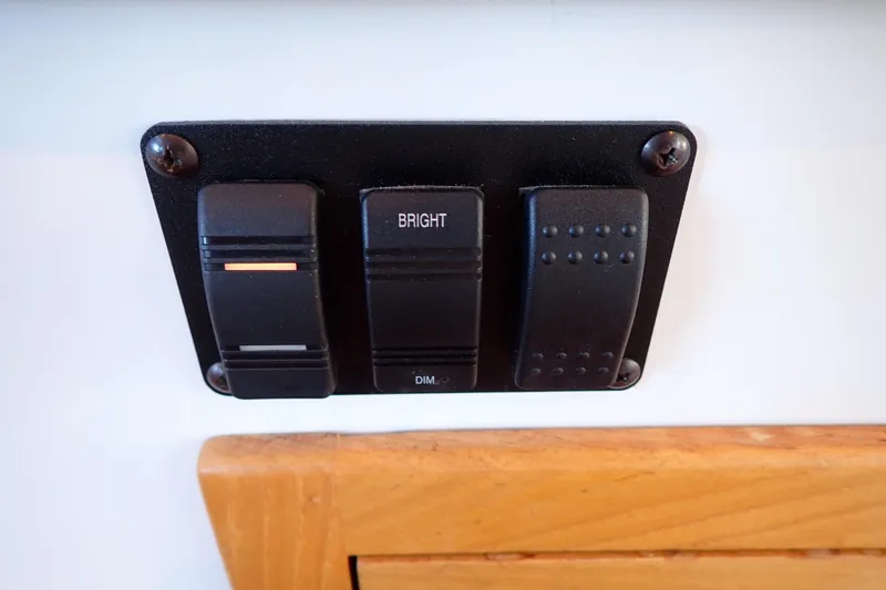 Slide: The Image of Control panel with switches on 2023 True North 34 Outboard Express boat. - 98