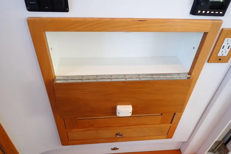 Slide: The Image of Wooden cabinet with open shelf and drawers in 2023 True North 34 Outboard Express boat. - 99