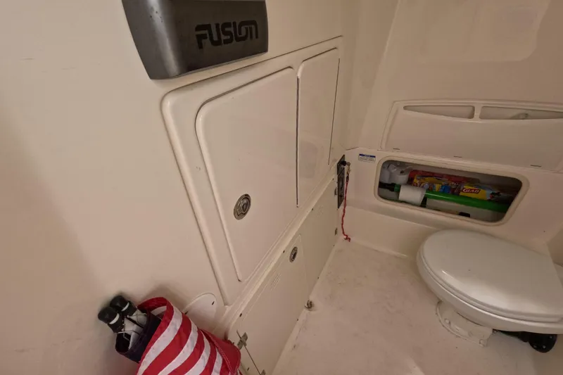 Slide: The Image of 2013 Boston Whaler 320 Outrage boat interior with covered console, docked by waterfront homes. - 22