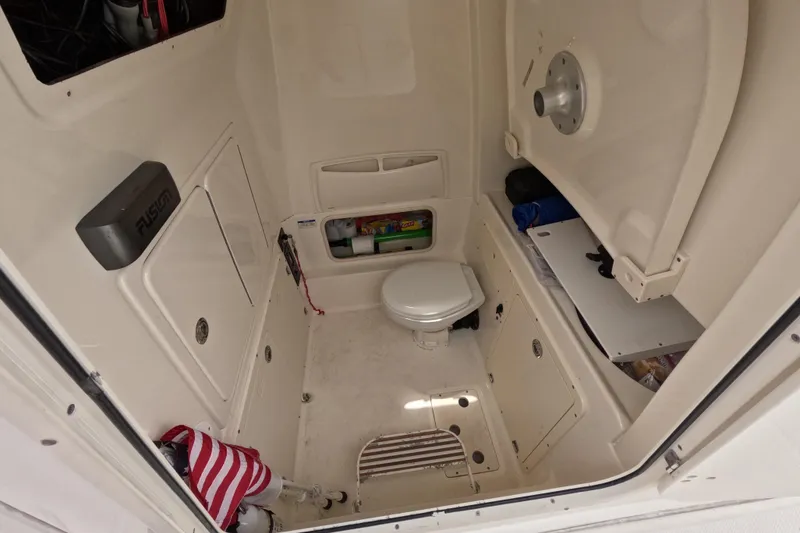 Slide: The Image of 2013 Boston Whaler 320 Outrage interior with covered seating and dockside view. - 24