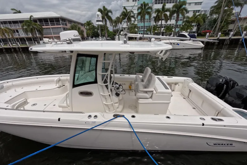 Slide: The Image of Man inspecting interior panel of 2013 Boston Whaler 320 Outrage boat. - 28