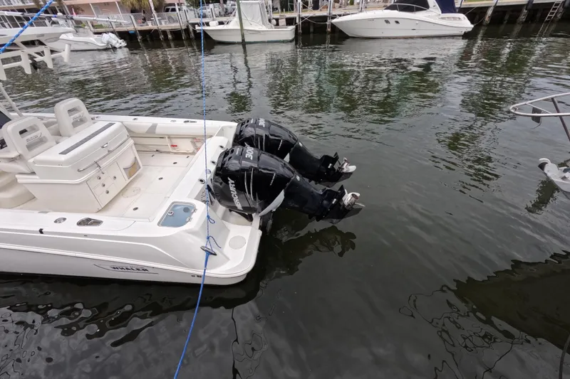 Slide: The Image of 2013 Boston Whaler 320 Outrage boat docked by waterfront buildings. - 30