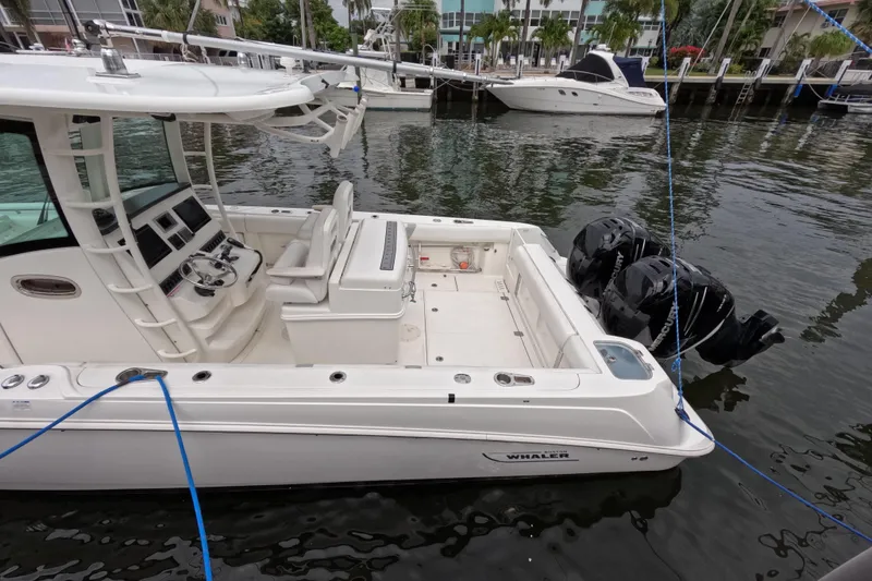 Slide: The Image of 2013 Boston Whaler 320 Outrage docked at marina with twin outboard engines. - 31