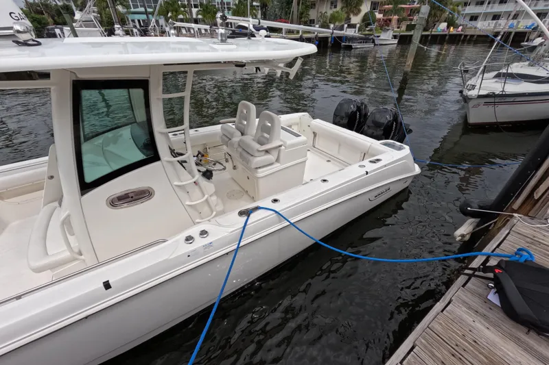 Slide: The Image of 2013 Boston Whaler 320 Outrage with dual outboard engines docked in marina. - 32
