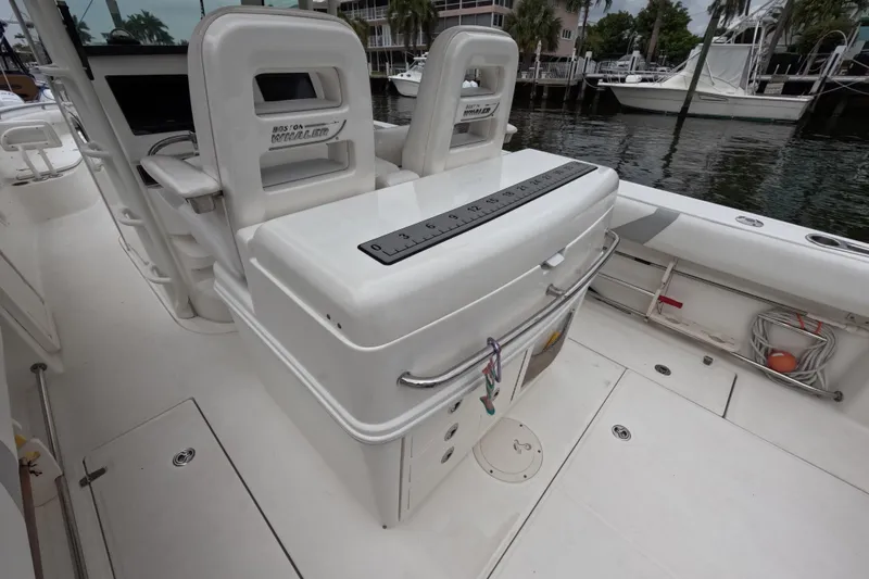 Slide: The Image of 2013 Boston Whaler 320 Outrage docked, showcasing helm and seating under cloudy sky. - 39