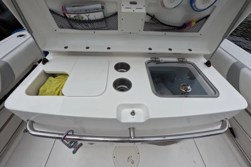 Slide: The Image of 2013 Boston Whaler 320 Outrage boat interior with seating and storage, docked by the water. - 41