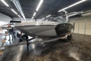 Slide: The Image of 2025 Supra SA boat in showroom, sleek design, on trailer. - 3