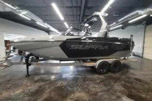 Slide: The Image of 2025 Supra SA boat in showroom, sleek design, black and white color scheme. - 4