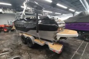 Slide: The Image of 2025 Supra SA boat in showroom, black and silver design, on trailer. - 6
