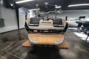 Slide: The Image of 2025 Supra SA boat in showroom, rear view with teak deck and seating. - 7