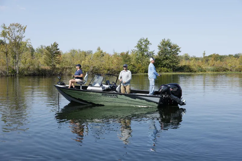 The Image of 2025 Smoker Craft Adventurer 188 DC boat on a serene lake with three people fishing. - 0