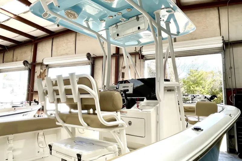 Slide: The Image of 2018 Sea Hunt Ultra 211 boat interior with seating and control panel in a garage. - 1