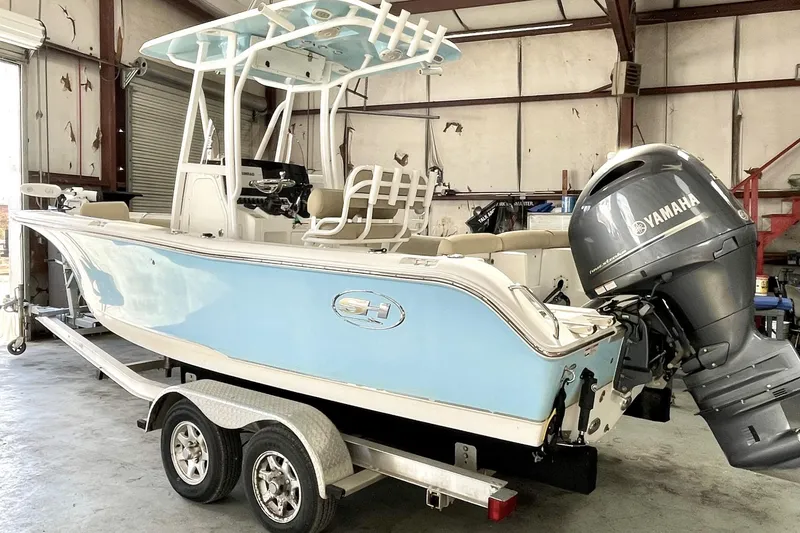 Slide: The Image of 2018 Sea Hunt Ultra 211 boat with Yamaha engine in a garage setting. - 2
