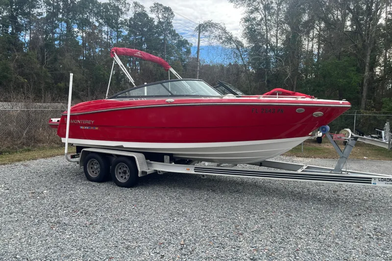 The Image of 2013 Monterey 214SS Super Sport boat on trailer, red and white, parked outdoors. - 0
