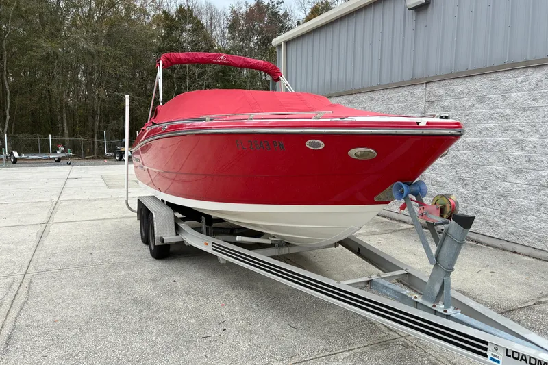 Slide: The Image of 2013 Monterey 214SS Super Sport boat on trailer, red cover, parked outdoors. - 29