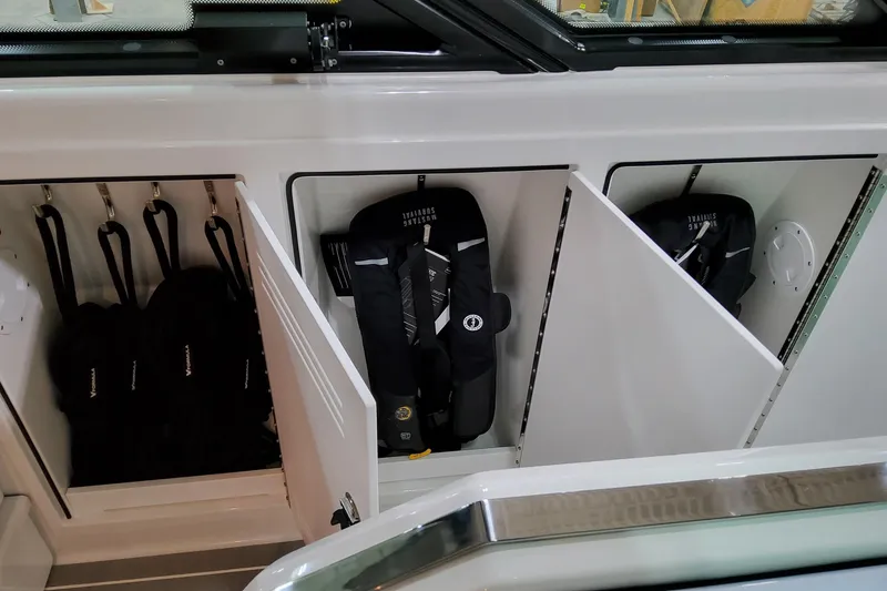 Slide: The Image of Storage compartments in a 2026 Formula 500 Super Sport Crossover boat, featuring life jackets. - 8