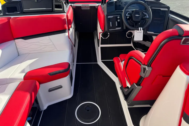 The Image of 2026 Supra SE 575 boat interior with red and white seating, modern dashboard, and steering wheel. - 1