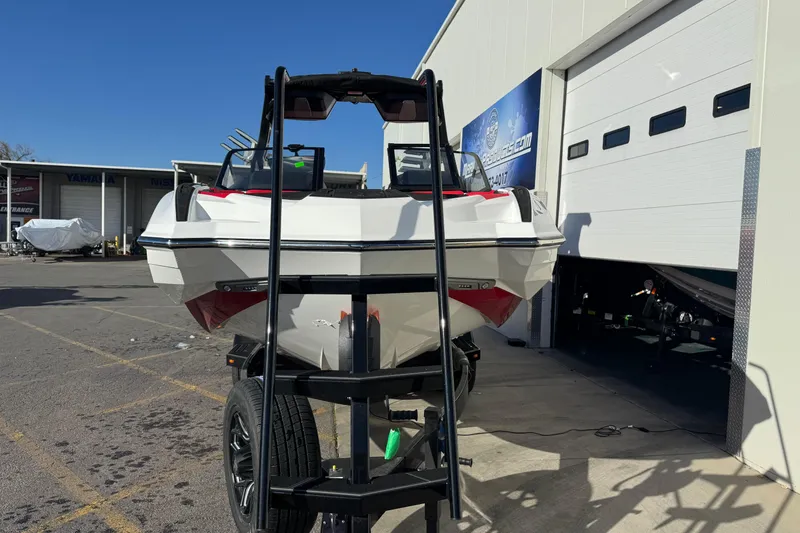 Slide: The Image of 2026 Supra SE 575 boat on trailer outside dealership, sunny day. - 7