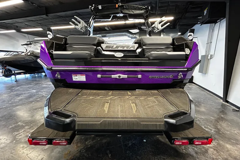 Slide: The Image of 2025 Supra SA boat in showroom, featuring sleek purple design and advanced wakeboarding features. - 3